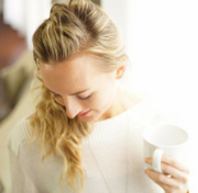 Brett Larkin looking down over her shoulder while holding a cup of tea