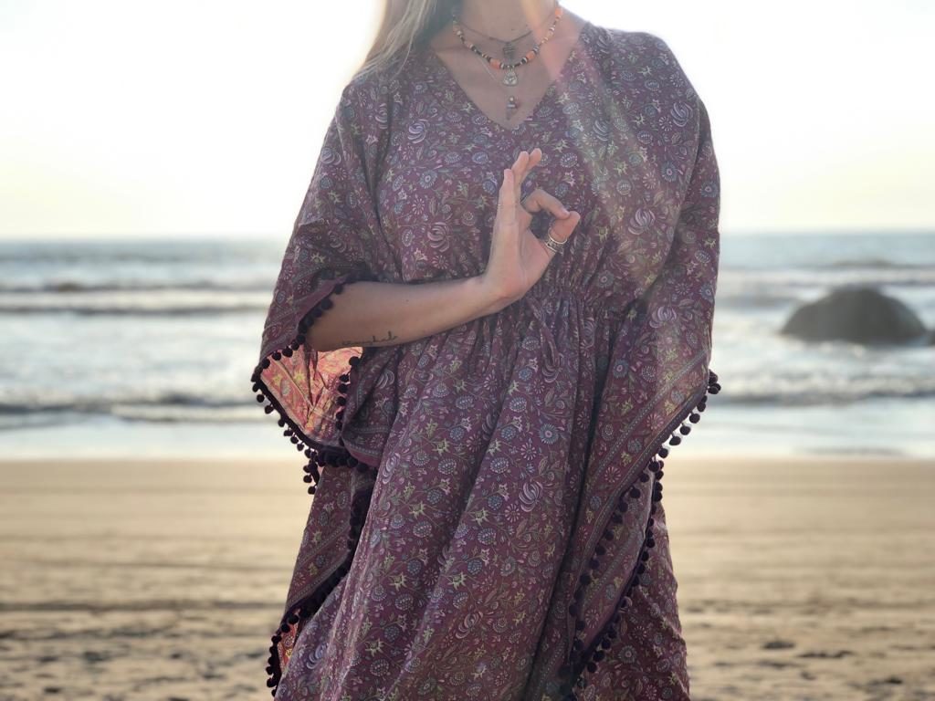 A woman doing a vitarka mudra with her hands on the beach