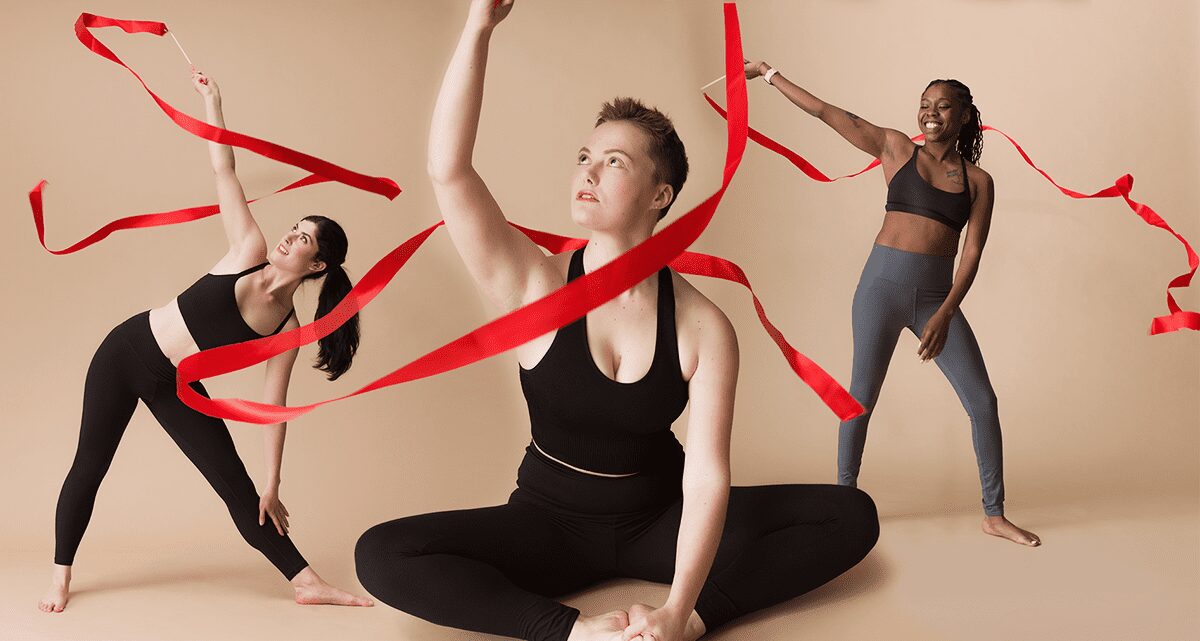 Three yogi women practicing yoga with ribbons as part of the 200-hour online yoga teacher training program.