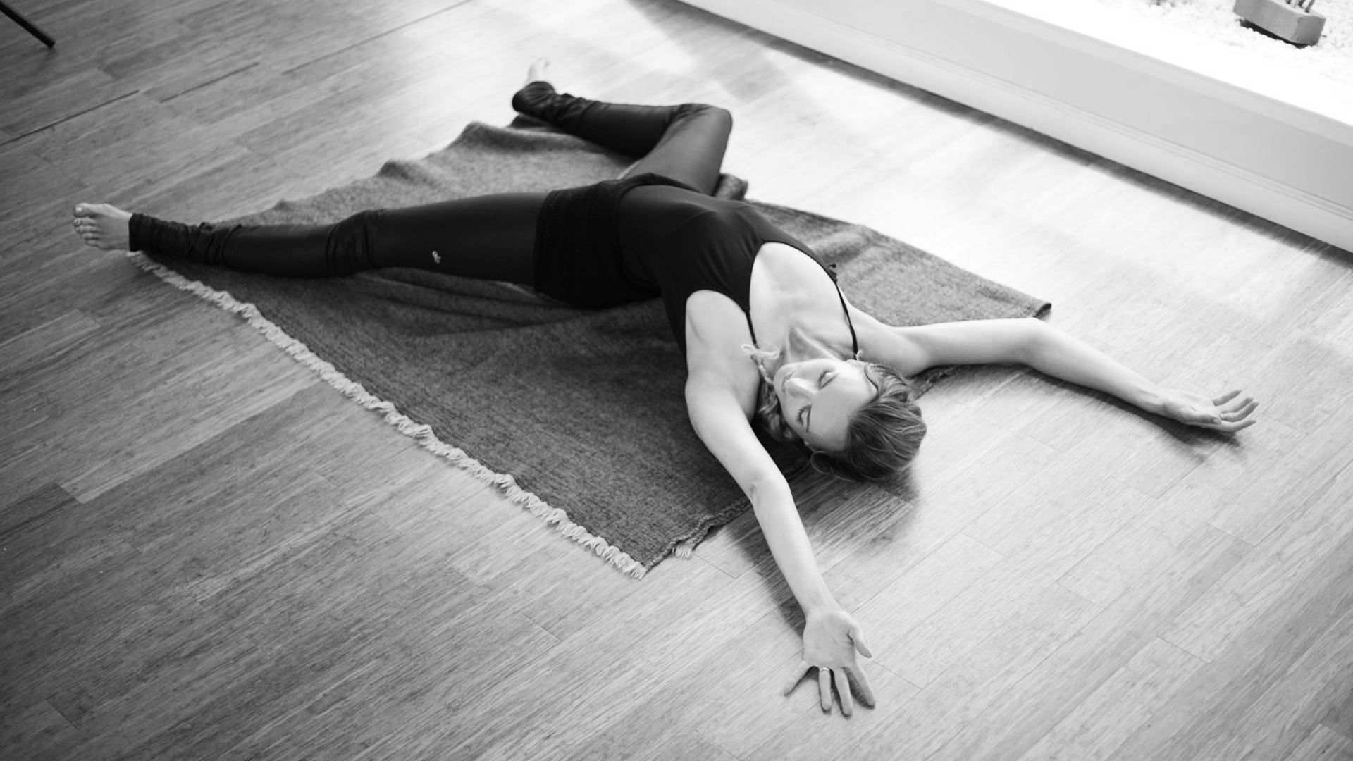 Brett Larkin doing somatic movement training relaxing and stretching on a yoga blanket