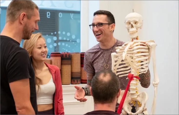 students learning anatomy biomechanics with skeleton in uplifted 300 hour yoga certification