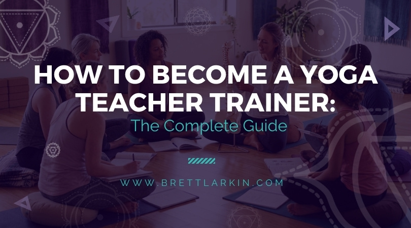 Brett Larkin mentoring a group of yoga teacher trainees in a bright studio